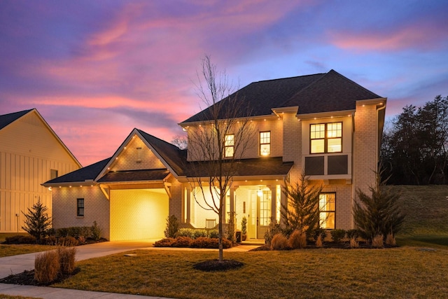 view of front of house with french doors, brick siding, roof with shingles, a front yard, and driveway