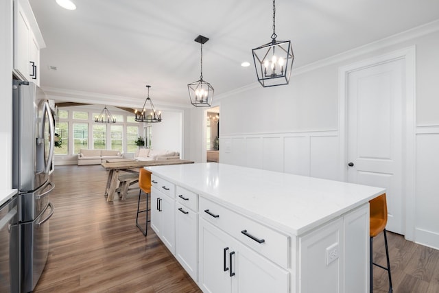 kitchen featuring a breakfast bar, dark wood-style flooring, white cabinetry, stainless steel refrigerator with ice dispenser, and crown molding