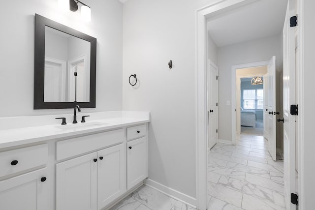 bathroom with marble finish floor, baseboards, and vanity