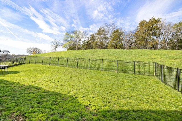 view of yard with a trampoline and a fenced backyard