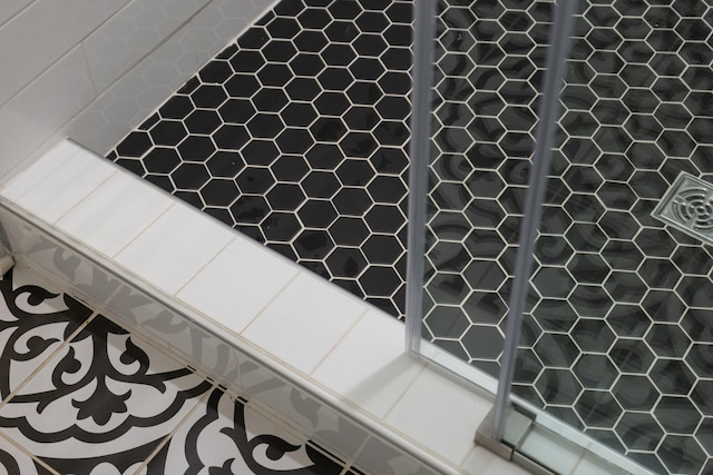 interior details featuring elevator and tiled shower