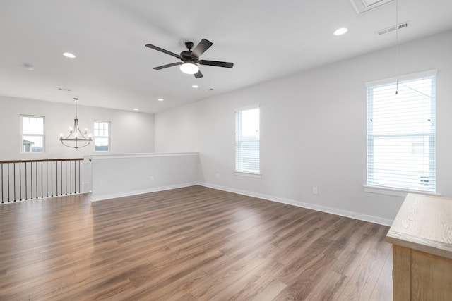 unfurnished room featuring attic access, baseboards, visible vents, wood finished floors, and recessed lighting