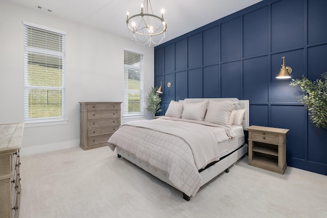 bedroom featuring a notable chandelier, visible vents, a decorative wall, light carpet, and baseboards