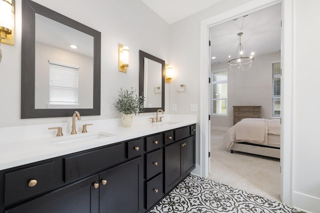 ensuite bathroom featuring double vanity, an inviting chandelier, a sink, and connected bathroom