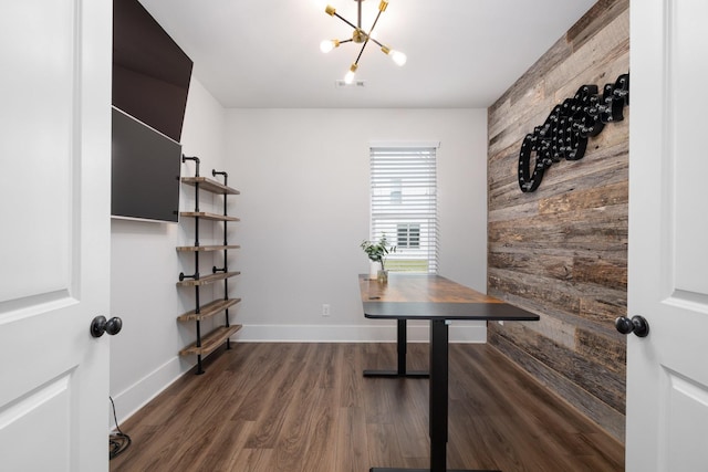 office featuring wood walls, wood finished floors, visible vents, baseboards, and an inviting chandelier