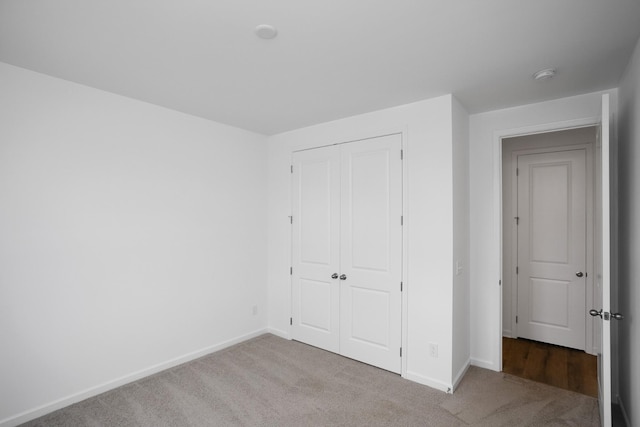 unfurnished bedroom featuring carpet flooring and a closet