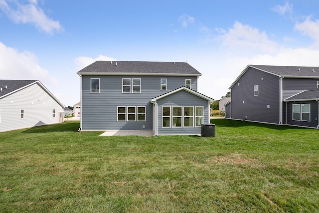 back of property with a patio, a yard, and central AC