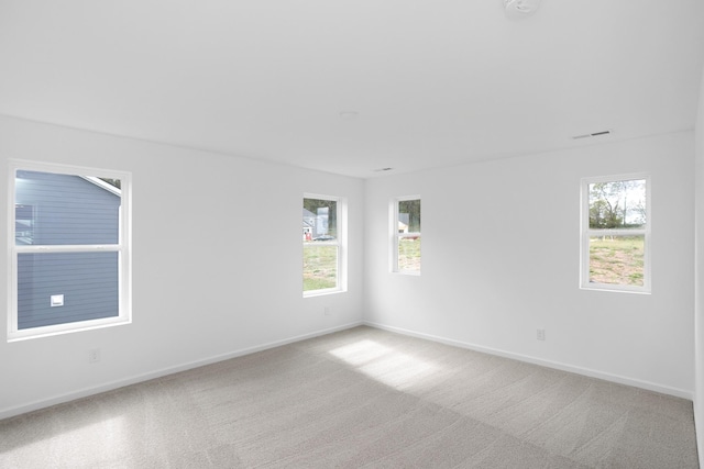 empty room with plenty of natural light and light colored carpet