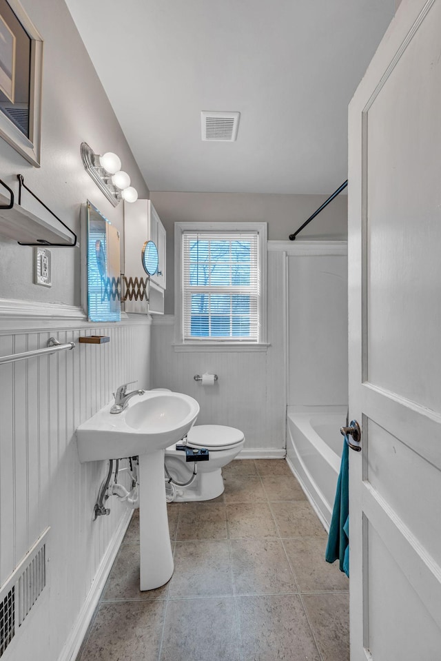 bathroom featuring shower / tub combination, tile patterned floors, and toilet