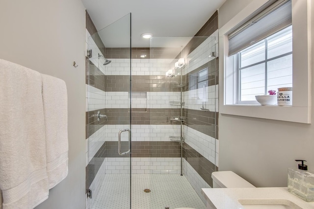 bathroom featuring vanity, toilet, and an enclosed shower