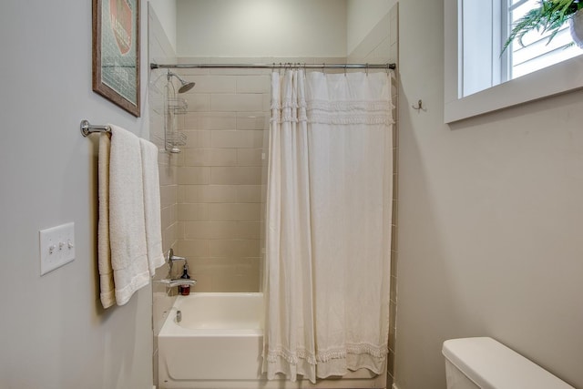 bathroom featuring shower / bath combination with curtain and toilet