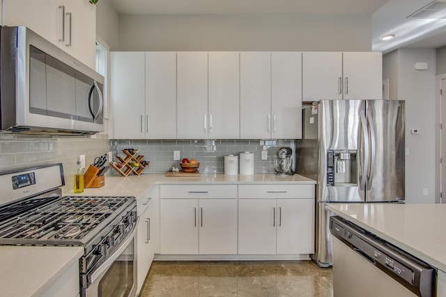 kitchen with tasteful backsplash, appliances with stainless steel finishes, and white cabinets