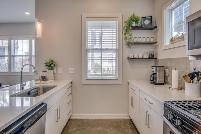 kitchen with sink, decorative light fixtures, stainless steel appliances, decorative backsplash, and white cabinets