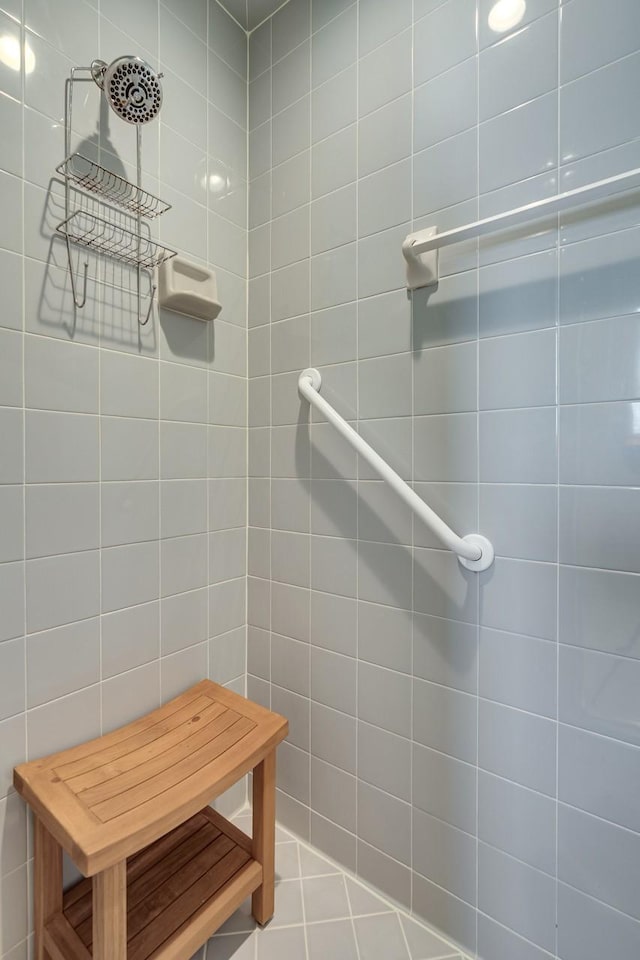 bathroom with tiled shower and tile walls