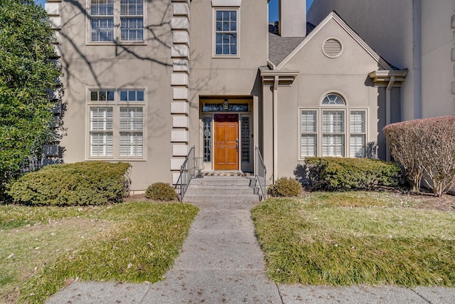 property entrance with a lawn