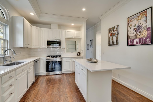 kitchen featuring a kitchen island, tasteful backsplash, sink, white cabinets, and stainless steel appliances