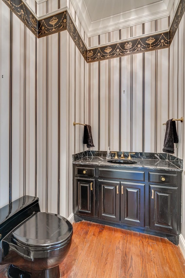 bathroom with sink, crown molding, and hardwood / wood-style floors