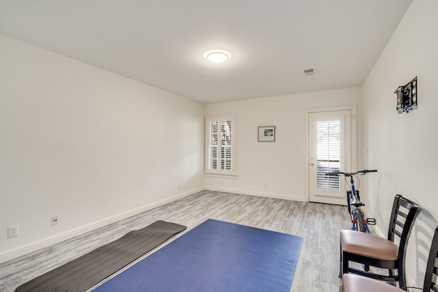 exercise room with light hardwood / wood-style floors