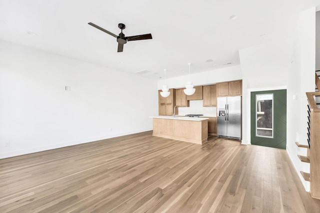 unfurnished living room with ceiling fan and light hardwood / wood-style floors