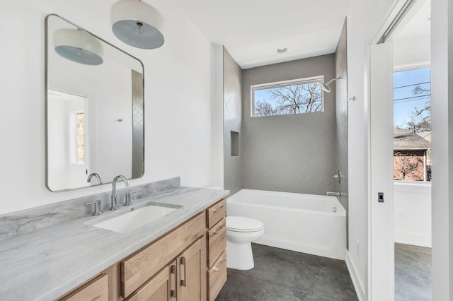 full bathroom featuring vanity, tiled shower / bath, and toilet