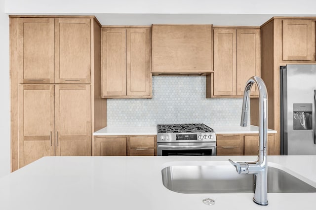 kitchen with tasteful backsplash, sink, and appliances with stainless steel finishes