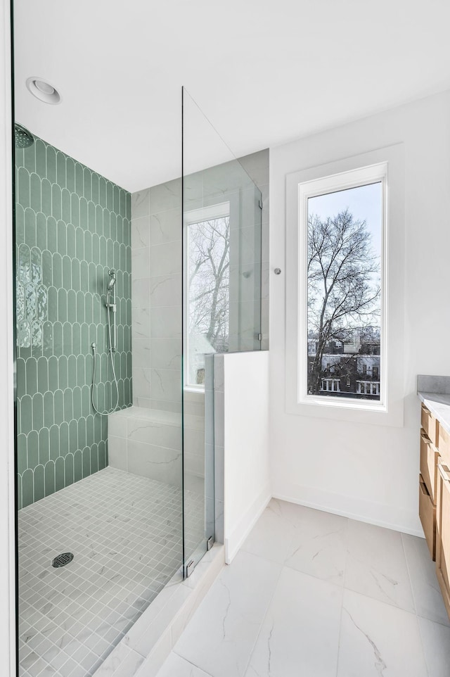 bathroom with vanity, plenty of natural light, and a tile shower