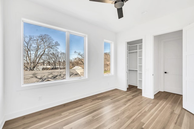 unfurnished bedroom with light hardwood / wood-style flooring, a closet, and ceiling fan