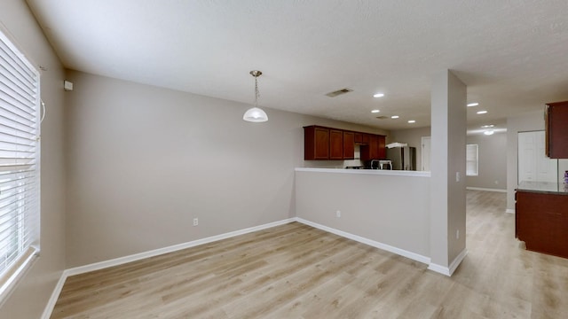 kitchen featuring stainless steel fridge with ice dispenser, light hardwood / wood-style flooring, hanging light fixtures, and kitchen peninsula