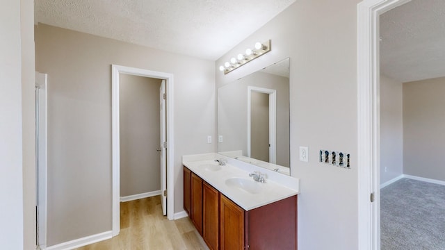 bathroom featuring hardwood / wood-style flooring, vanity, and a textured ceiling