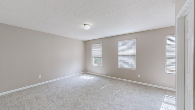 carpeted empty room with a textured ceiling