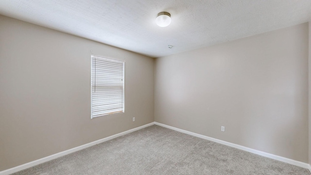 carpeted spare room featuring a textured ceiling