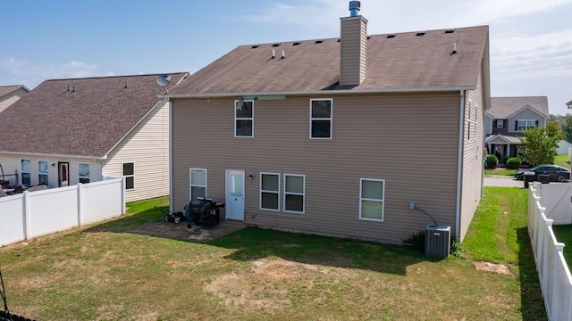 rear view of property featuring cooling unit, a lawn, and a patio