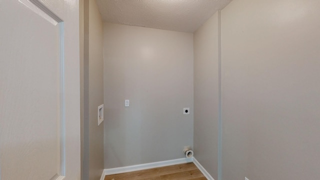 washroom featuring electric dryer hookup, hardwood / wood-style flooring, and a textured ceiling