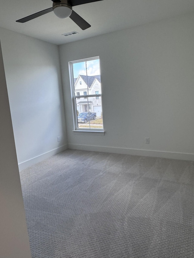 carpeted spare room featuring ceiling fan