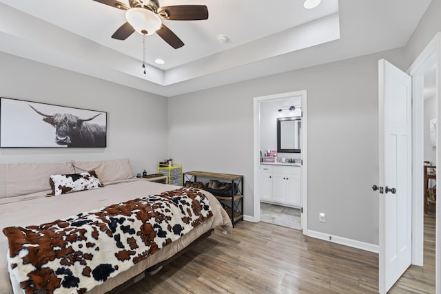 bedroom featuring connected bathroom, wood-type flooring, and ceiling fan