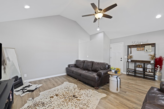 living room featuring ceiling fan, vaulted ceiling, and light hardwood / wood-style flooring