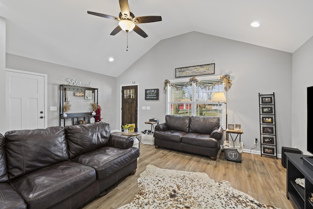 living room featuring ceiling fan, lofted ceiling, and light hardwood / wood-style floors