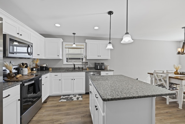 kitchen featuring pendant lighting, white cabinetry, and stainless steel appliances