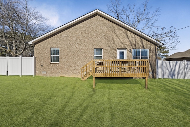 rear view of property featuring a wooden deck and a yard