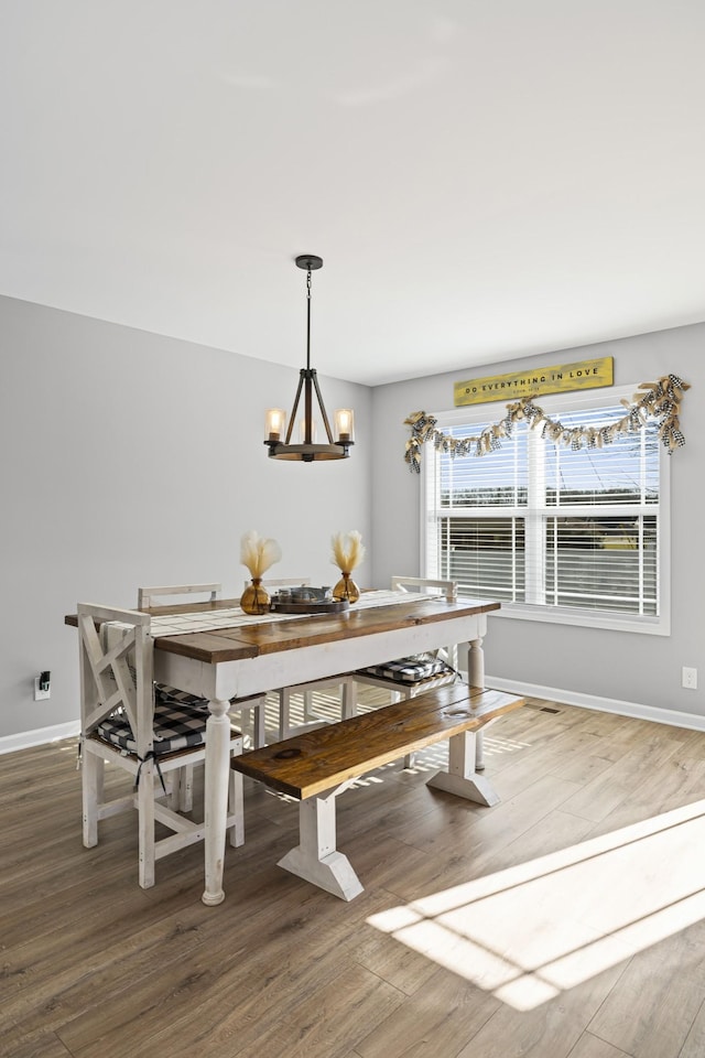 dining space featuring hardwood / wood-style floors, a wealth of natural light, and a chandelier