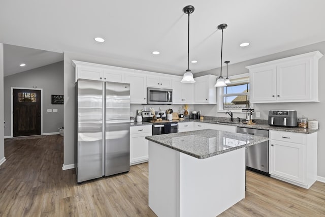 kitchen featuring a kitchen island, white cabinetry, sink, hanging light fixtures, and stainless steel appliances