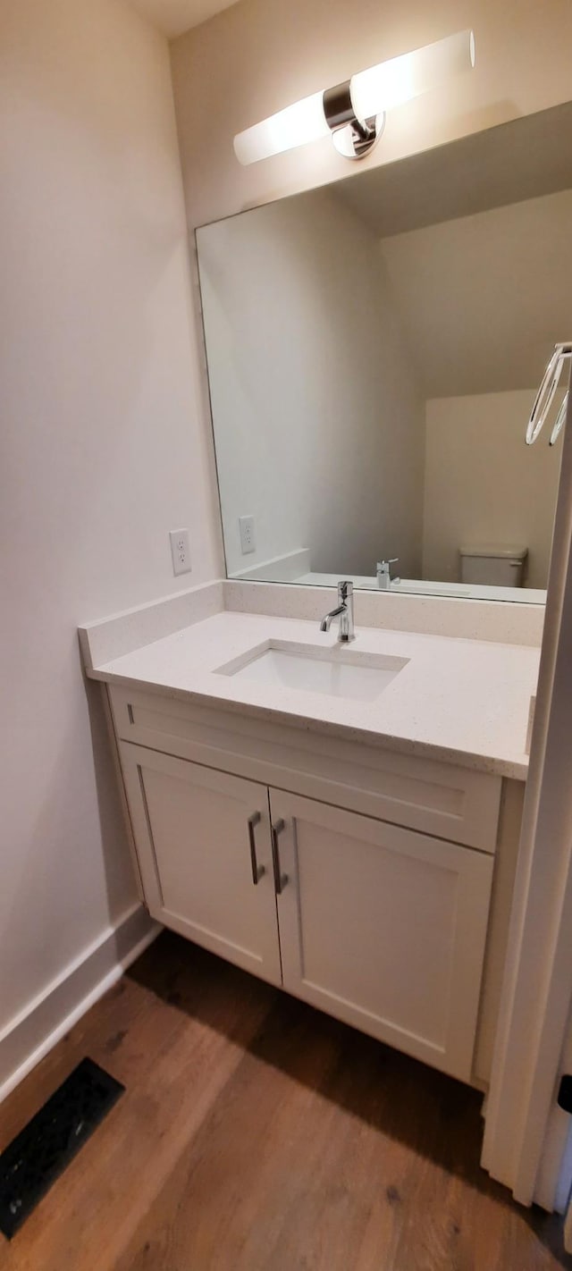 bathroom with vanity, hardwood / wood-style floors, and toilet