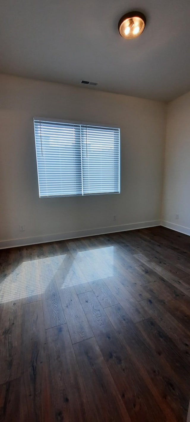 empty room with dark hardwood / wood-style flooring