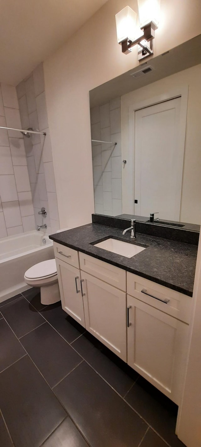 full bathroom with tiled shower / bath, vanity, toilet, and tile patterned floors