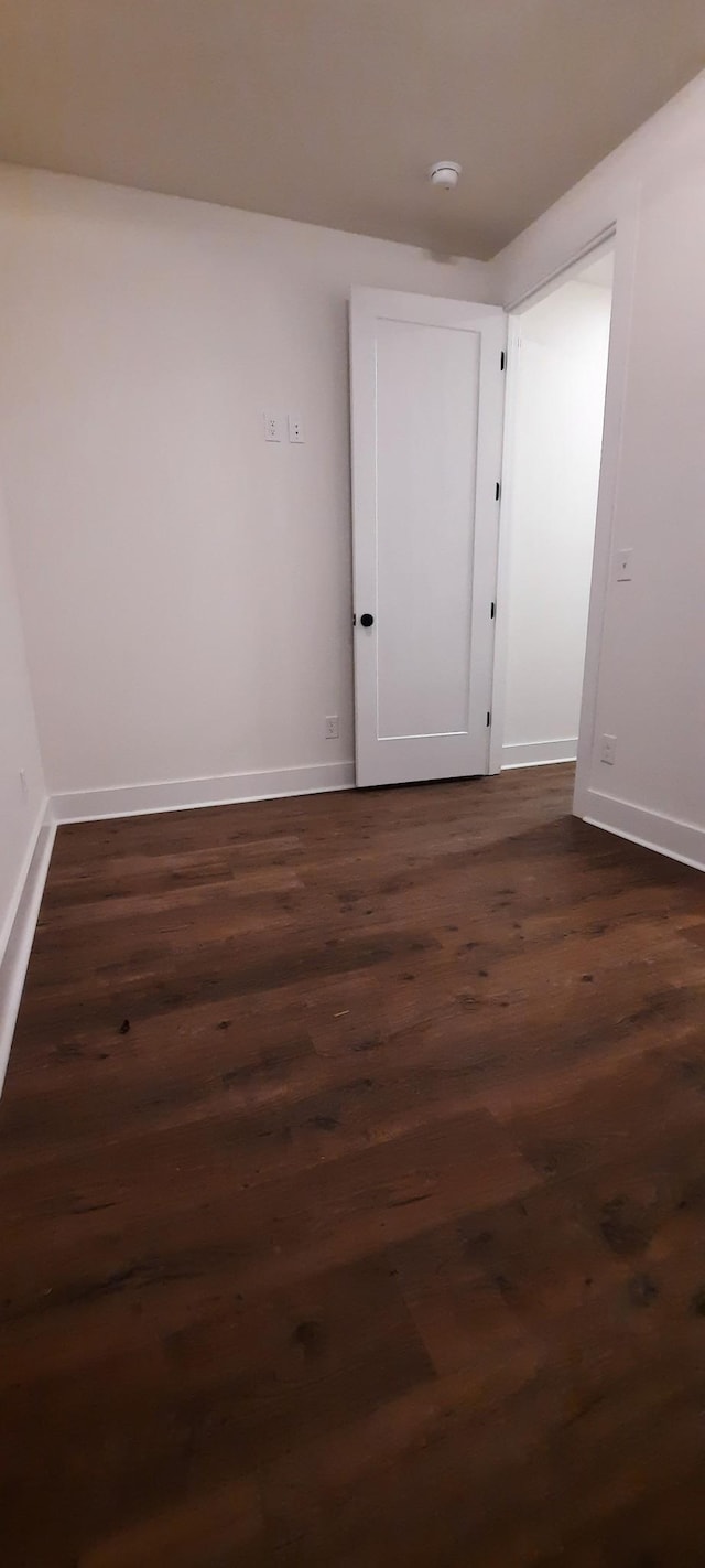 spare room featuring dark wood-type flooring