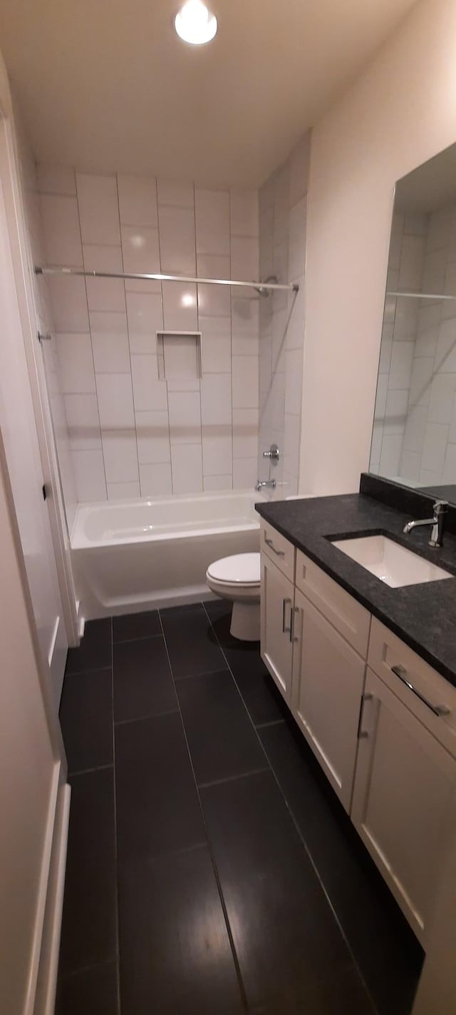 full bathroom featuring tiled shower / bath combo, vanity, tile patterned floors, and toilet