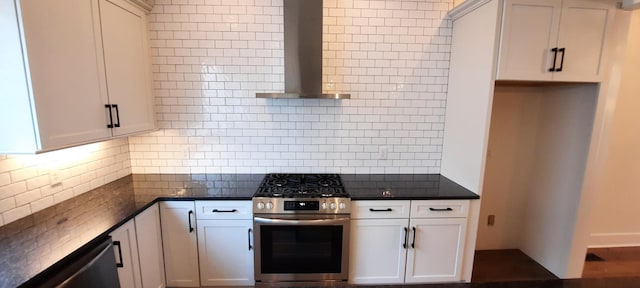 kitchen with tasteful backsplash, stainless steel gas range oven, white cabinets, and wall chimney exhaust hood