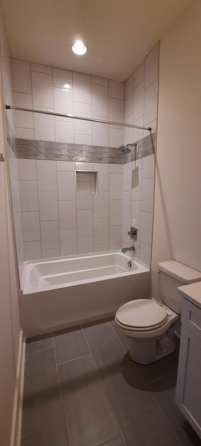 full bathroom featuring vanity, tile patterned flooring, toilet, and tiled shower / bath