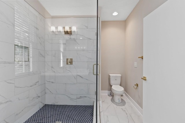 bathroom featuring a shower with shower door and toilet