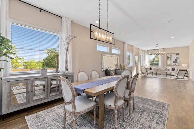 dining space with wood-type flooring, a chandelier, and a wealth of natural light